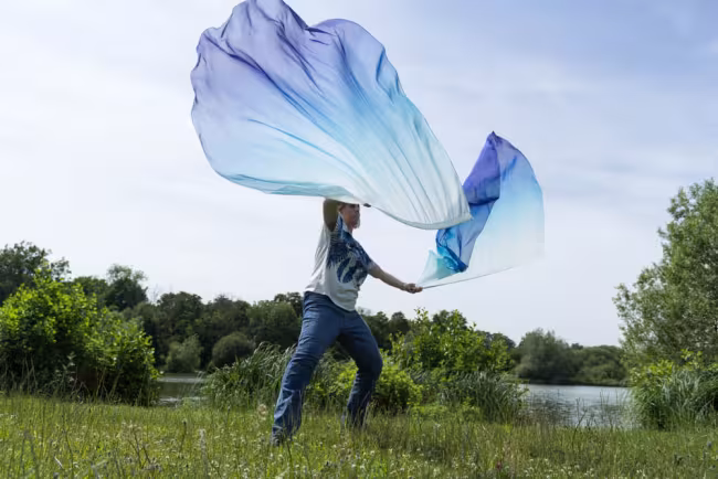 Mands dancing with ribbon streamers beside a lake